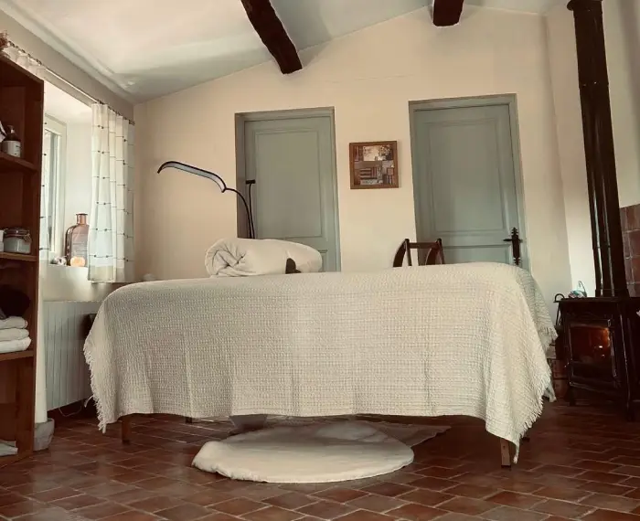 Table de soin habillée de lin crème dans la cabine du Clos du Soin