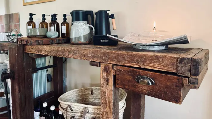 Console en bois ancien avec huiles de massage et bougie, au Clos du Soin